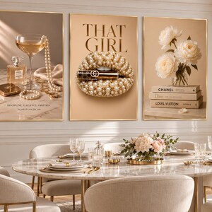 May include: A set of three framed wall art prints featuring luxury fashion themes. The left print shows a perfume bottle, champagne glass, and pearls. The center print displays pearl-encrusted lips with the text THAT GIRL. The right print shows white flowers on stacked designer books.