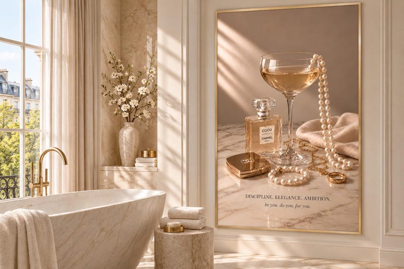 May include: A framed wall art print featuring a glass of champagne, a bottle of Coco Mademoiselle perfume, a gold compact, and pearl jewelry on a marble surface. The text reads: DISCIPLINE, ELEGANCE, AMBITION. be you. do you. for you.