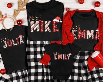 May include: A family Christmas pajama set featuring black shirts with names in a candy cane font. The pajamas include black and white plaid pants. Christmas ornaments and reindeer antlers are included in the image.