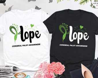 May include: Two t-shirts, one white and one black, with a green ribbon and the word "Hope" in black lettering. The text "Cerebral Palsy Awareness" is written below the word "Hope" on both shirts.