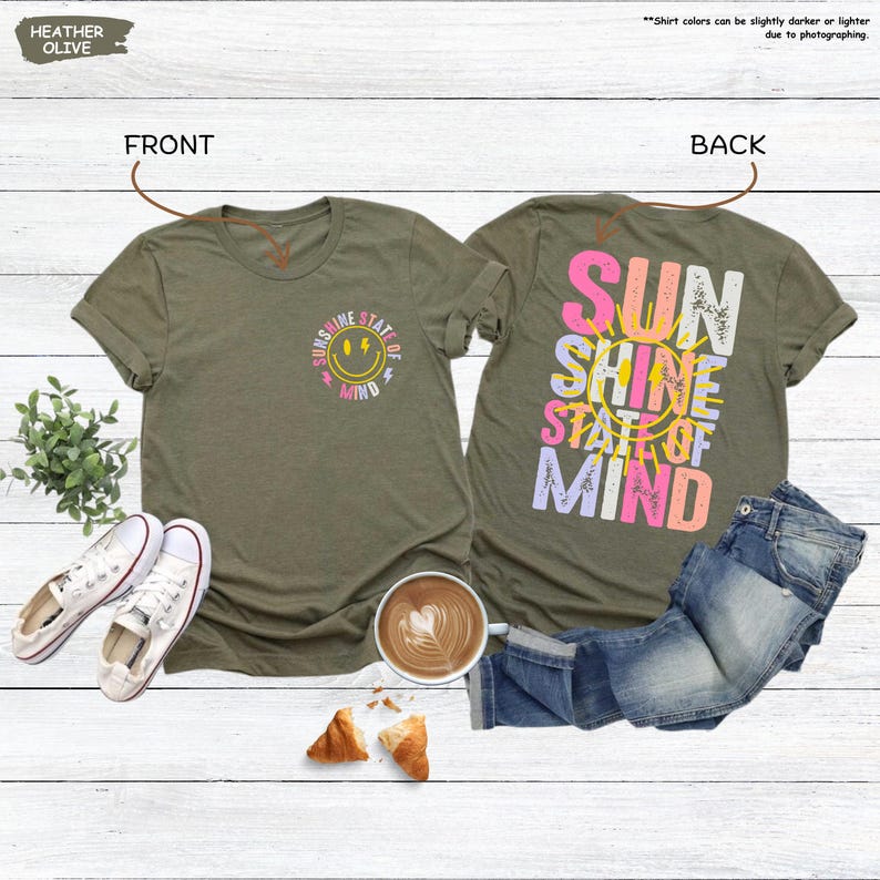Pu&ograve; includere: T-shirt verde oliva melange con grafica "Sunshine State of Mind" sul davanti e sul retro. Il davanti presenta una faccina sorridente e testo, mentre il retro mostra le parole "Sun Shine State of Mind" a colori.