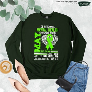 a green sweatshirt with the words mental health awareness month on it