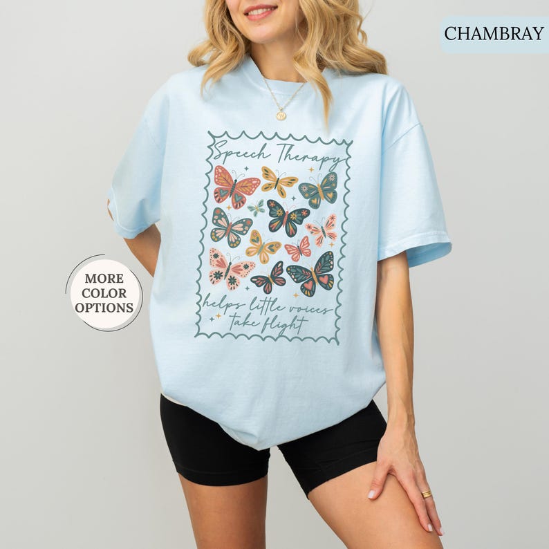 Puede incluir: Camiseta azul claro con un gr&aacute;fico de mariposas y el texto "Speech Therapy helps little voices take flight". El dise&ntilde;o presenta mariposas coloridas en varios tama&ntilde;os y patrones. La camiseta es de un material suave y c&oacute;modo.