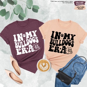 two t - shirts that say in my bulldog's ear and in my bulldog