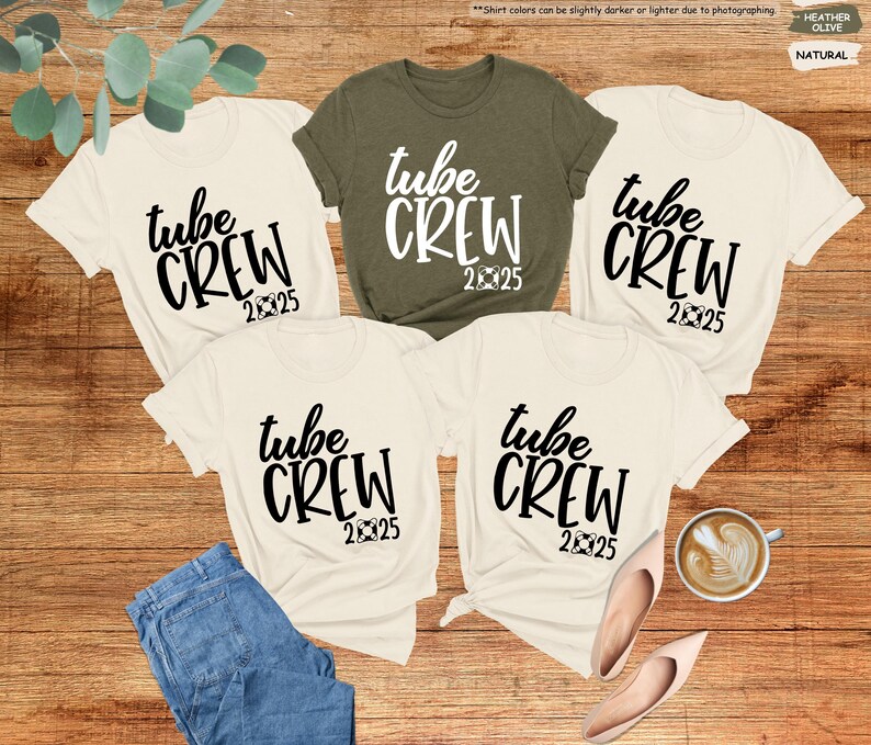 May include: Four white t-shirts with black text that reads "tube crew 2025". One of the shirts is olive green.