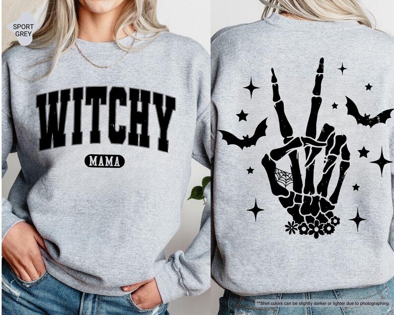 a woman wearing a grey sweater with a witch hand on it