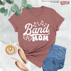 a t - shirt that says band mom next to a cup of coffee