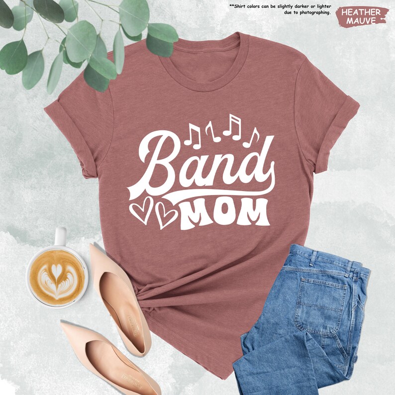 a t - shirt that says band mom next to a cup of coffee