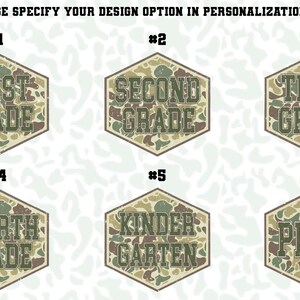 May include: Six hexagonal designs with grade level text, each with a camouflage pattern. The text includes "First Grade" and "Pre-K". The text "PLEASE SPECIFY YOUR DESIGN OPTION IN PERSONALIZATION BOX" is at the top of the image.
