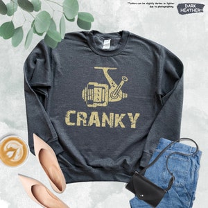 a sweater with the word cranky on it next to a pair of jeans and