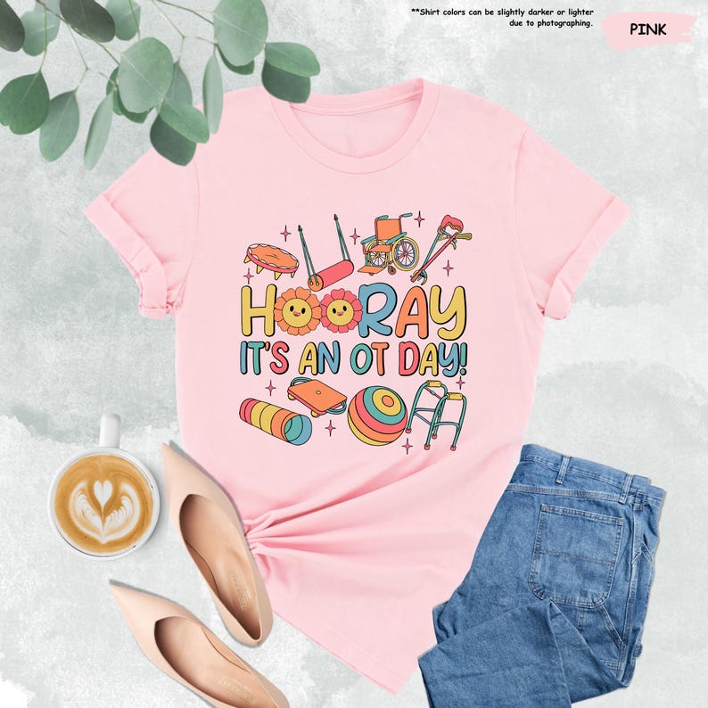 Peut inclure: T-shirt rose avec un motif graphique d'outils d'ergoth&eacute;rapie et le texte "HOORAY IT'S AN OT DAY!"