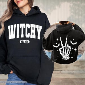 a woman wearing a black witch hoodie and a black sweatshirt