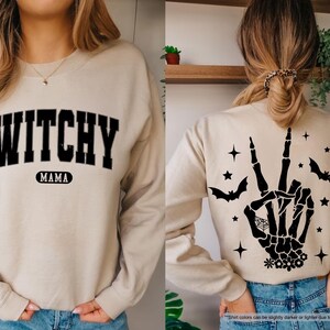 a woman wearing a sweater with a witch hand on it