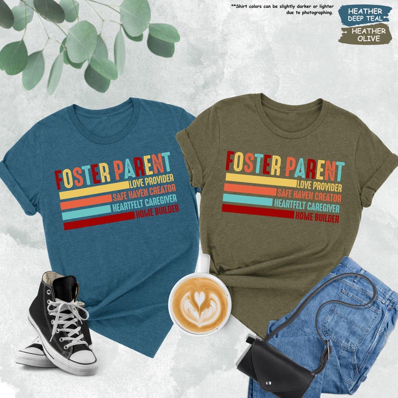 May include: Two t-shirts with the text "Foster Parent" in a retro rainbow design. The text is layered over a series of colorful stripes. The shirts are in heather deep teal and heather olive.
