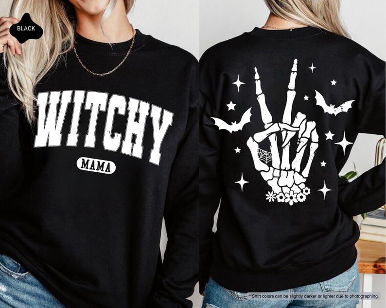 a woman wearing a black sweater with a hand print on it