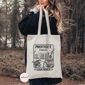 May include: A white canvas tote bag with black text and a graphic of books and a quill pen. The text reads "Protect Public Libraries".