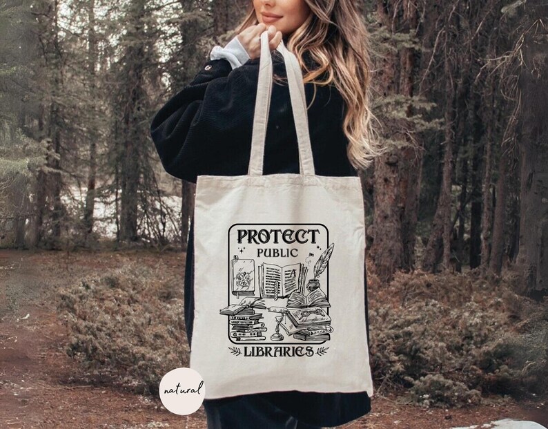 May include: A white canvas tote bag with black text and a graphic of books and a quill pen. The text reads "Protect Public Libraries".