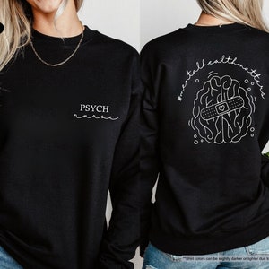 a woman wearing a black sweatshirt with the words psychic on it