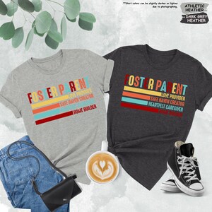 May include: Two t-shirts with the text "Foster Parent" in a retro style. The shirts are in heather grey and dark grey heather. The text on the shirts includes the words "Love Provider", "Safe Haven Creator", "Home Builder", and "Heartfelt Caregiver".