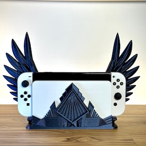 May include: A black 3D printed stand with wings for a Nintendo Switch console. The stand features a geometric design and is made of a durable plastic.