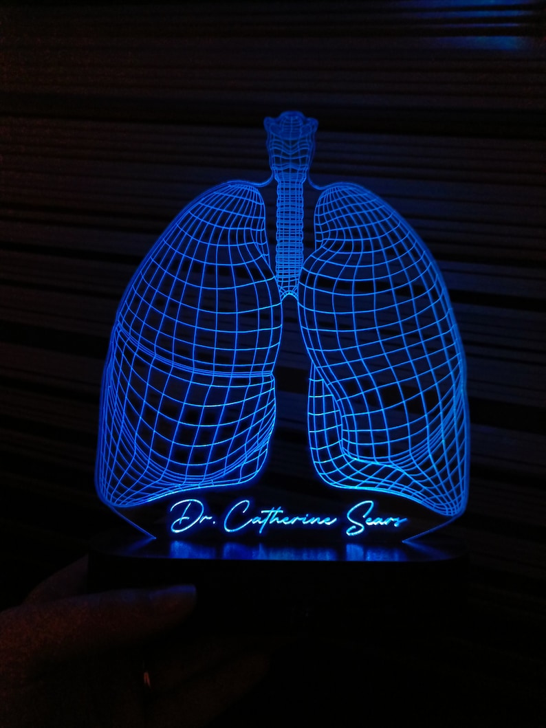 May include: A blue 3D printed light sculpture of a pair of lungs with the text "Dr. Catherine Sears" underneath.