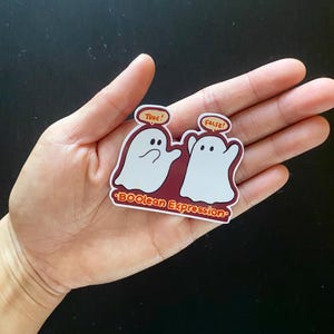May include: Two white ghost stickers with speech bubbles. The ghost on the left says "True!" and the ghost on the right says "False!" The sticker is on a red background with the text "*BOOlean Expression*" in orange.