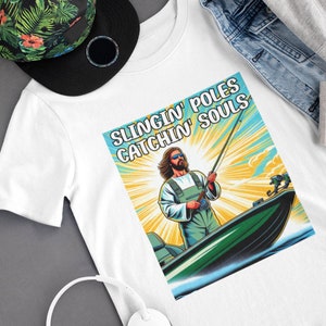 May include: White t-shirt with a graphic of a man in a boat fishing. The graphic says "Slingin' Poles Catchin' Souls".