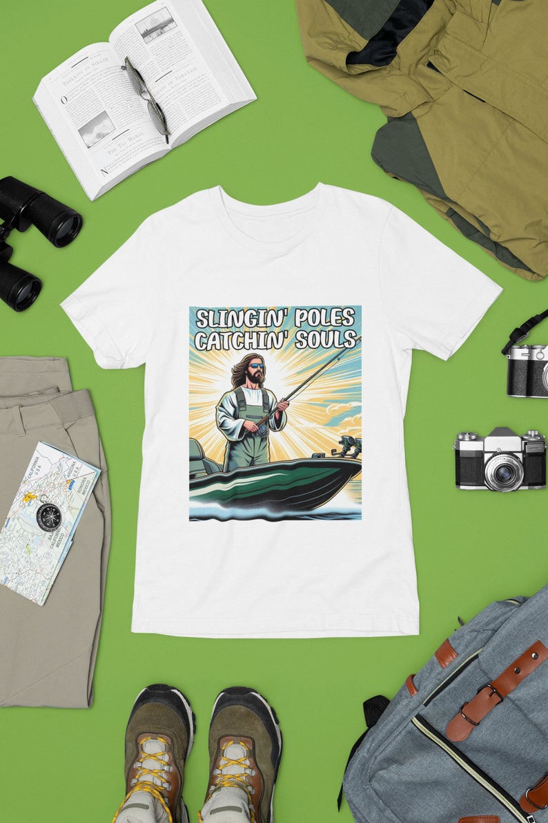 May include: White t-shirt with a graphic of Jesus fishing from a boat with the text "Slingin' Poles Catchin' Souls".