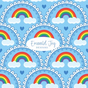 May include: A repeating pattern on a light blue background featuring scalloped semi-circles with small bow accents, each containing a colorful rainbow above white clouds and a small heart. An oval label in the center reads Emerald Joy DESIGNS.