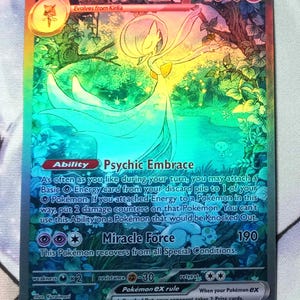 May include: A Gardevoir EX Pokemon card from the Pokemon Trading Card Game. The card is holographic and features a colorful illustration of Gardevoir. The card's text reads "Gardevoir EX, HP 310, Evolves from Kirlia, Ability: Psychic Embrace, Miracle Force 190, Weakness: x2, Resistance: -30, Retreat: **, Pokemon EX Rule: When your Pokemon EX is Knocked Out, your opponent takes 2 Prize cards."