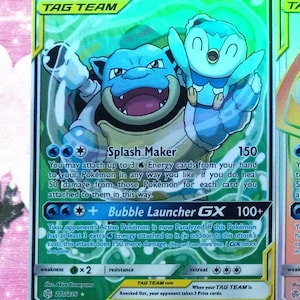 May include: A green, blue, and white Pokemon trading card featuring Blastoise & Piplup GX. The card has a picture of Blastoise and Piplup, and the text "Blastoise & Piplup GX" and "HP 270". The card also has the text "Splash Maker" and "Bubble Launcher GX" with their corresponding attack descriptions.