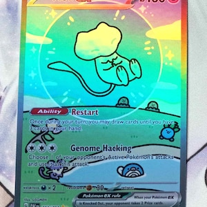 May include: A holographic Pokemon trading card featuring Mew EX, a light blue and yellow Pokemon with a tail. The card has a light blue background with green grass and a light blue Pokemon in the background. The card text reads "Restart" and "Genome Hacking".