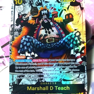 May include: A collectible trading card featuring Marshall D Teach, a character from the anime and manga series One Piece. The card is holographic and features a colorful illustration of the character. The card is part of the Blackbeard Pirates set and has a power level of 12000.