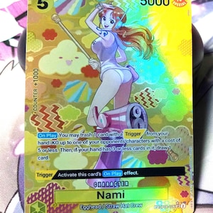 May include: A yellow and orange trading card featuring an anime character named Nami from the Straw Hat Crew. The card has a counter value of +1000 and a power value of 5000. The card text reads "On Play You may trash 1 card with a Trigger from your hand: KO up to one of your opponents characters with a cost of 5 or less. Then, if your hand has 3 or less cards in it, draw 1 card. Trigger Activate this card's On Play effect. CHARACTER Nami Egghead/Straw Hat Crew OP08-1062"