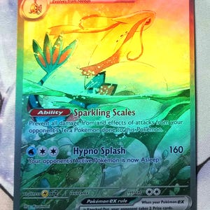 Peut inclure: Une carte de jeu de commerce Pok&eacute;mon holographique repr&eacute;sentant Milotice EX, un Pok&eacute;mon de type eau avec un sch&eacute;ma de couleurs rose, orange et bleu. La carte a une capacit&eacute; d'&eacute;cailles scintillantes et une attaque d'&eacute;claboussure hypnotique. Le num&eacute;ro de la carte est 237/191.