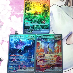 May include: Three Pokemon trading cards featuring the characters Gouging Fire EX, Walking Wake EX, and Raging Bolt EX. The cards are holographic and feature the characters in their Ancient forms.