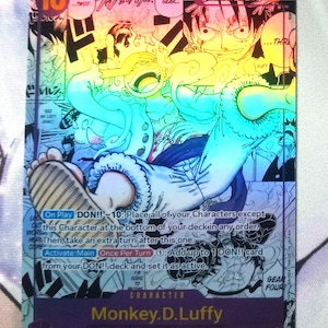 May include: A collectible trading card featuring Monkey D. Luffy from the anime series One Piece. The card is holographic and features a colorful illustration of Luffy in his Gear Fourth form. The card text reads "DON!! - 10: Place all of your Characters except this Character at the bottom of your deck in any order. Then, take an extra turn after this one. Activate: Main Once Per Turn 1: Add up to 1 DON!! card from your DON!! deck and set it as active."