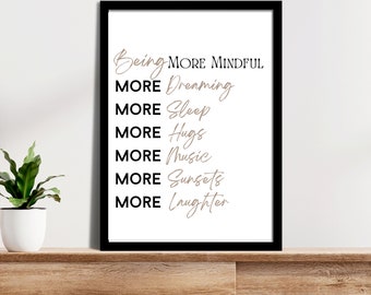 May include: Black framed print with white background and brown text that reads "Being More Mindful, More Dreaming, More Sleep, More Hugs, More Music, More Sunsets, More Laughter."
