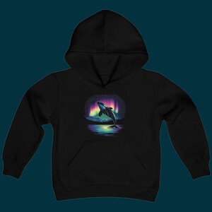 Può includere: Felpa con cappuccio nera con una grafica di un'orca che salta davanti a un'aurora boreale colorata.