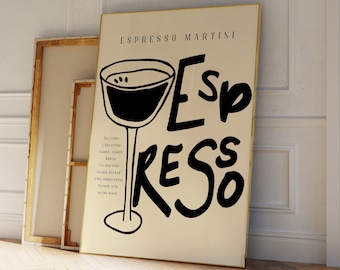 May include: A black and white poster with the text "Espresso Martini" and a stylized illustration of a martini glass. The poster has a gold frame and is leaning against a white wall.