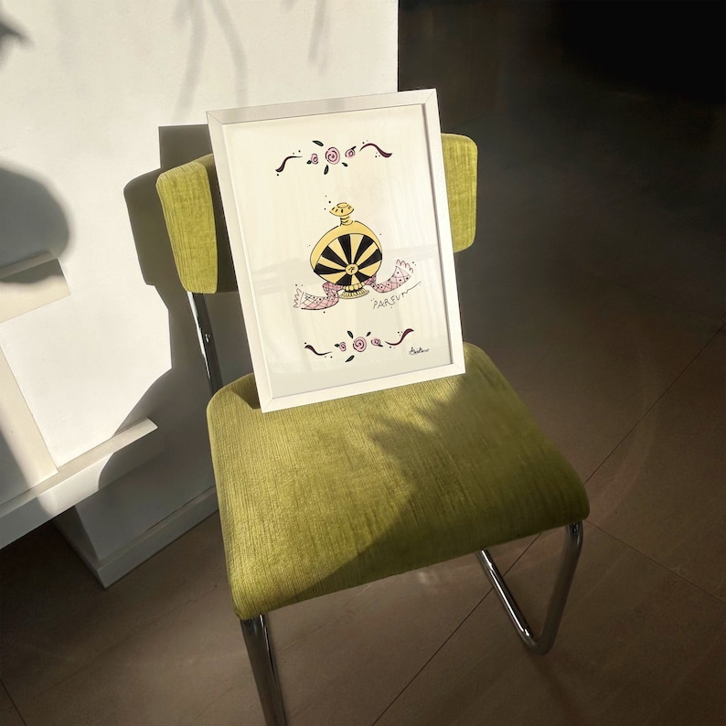 May include: A framed art print featuring a whimsical perfume bottle design with black and yellow details, the word "PARFUM" and floral accents. The artwork is displayed on a green chair with chrome legs, set against a bright background.