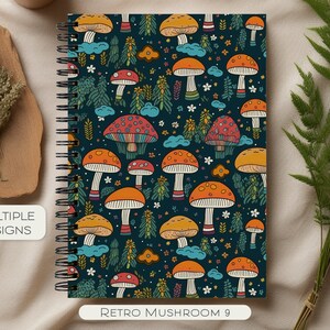 Può includere: Un quaderno a spirale con un motivo retrò di funghi colorati sulla copertina. I funghi sono rossi, arancioni, gialli e marroni con macchie bianche. Lo sfondo è blu scuro con accenti verdi e bianchi. Il testo "Retro Mushroom 9" è stampato nella parte inferiore della copertina.