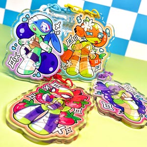 May include: Four colorful acrylic charms with cartoon characters. The charms feature a blue and green character, an orange character, a red and purple character, and a purple and green character. Each charm has a clear border and a keychain attachment.