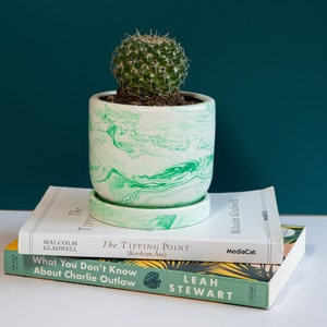 a green concrete planter on top of books