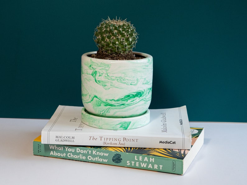 a green concrete planter on top of books