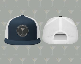 Pode incluir: Um chapéu de caminhoneiro azul marinho e branco com um logotipo preto e branco que diz "Liz's Martini Club est. 2021 - Las Vegas NV". O logotipo apresenta uma taça de martini com uma azeitona verde.