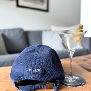 以下が含まれることがあります： 後ろに「TINI TIME」と刺繍されたネイビーのコーデュロイ製のベースボールキャップです。