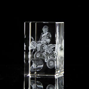 May include: A 3D crystal cube with a laser-engraved image of a young person riding a Yamaha ATV. The image is in black and white and the ATV has the number 117 on it.