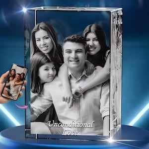 May include: A 3D crystal photo cube with a black and white photo of a family of four. The photo shows a man with two daughters and a younger girl. The text "Unconditional Love" is engraved on the bottom of the cube.