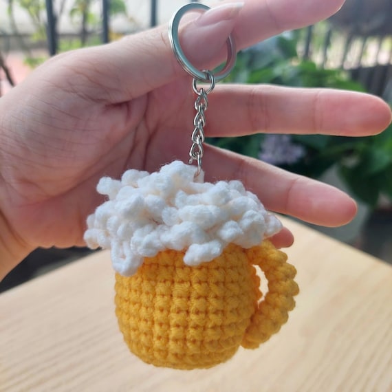 Miniature crocheted beer mug keychain — impossibly cute, clearly handmade, and actually wearable every day.